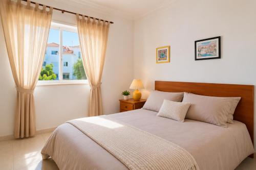 a bedroom with a large bed and a window at Apartamento Oásis Parque 3 in Portimão