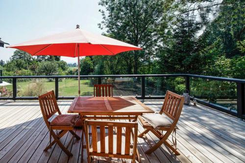 a wooden table with two chairs and a red umbrella at Immas Welt in Utting