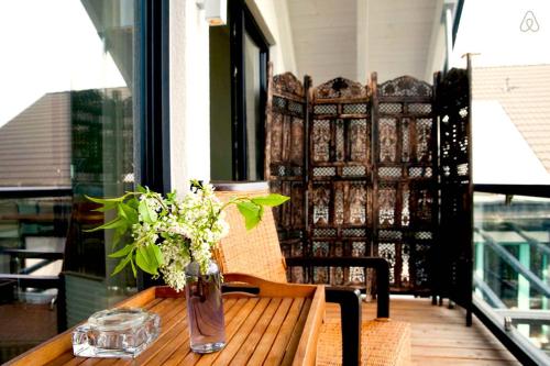 a vase of flowers on a wooden table on a balcony at Immas Welt in Utting
