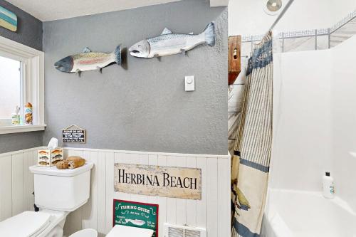 a bathroom with two fish decorations on the wall at Cozy Cottage w/ Hot Tub in Freeland, Pets Welcome! in Freeland