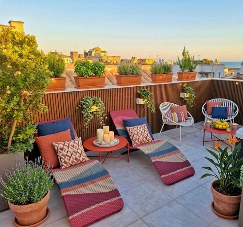 a rooftop patio with chairs and tables and plants at Marmori Suites Cagliari in Cagliari
