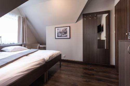 a bedroom with a large bed and a mirror at Walkowy Dwor in Zakopane