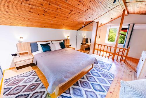 a bedroom with a bed and a wooden ceiling at Вила Бучала Villa Buchala in Dyakovo