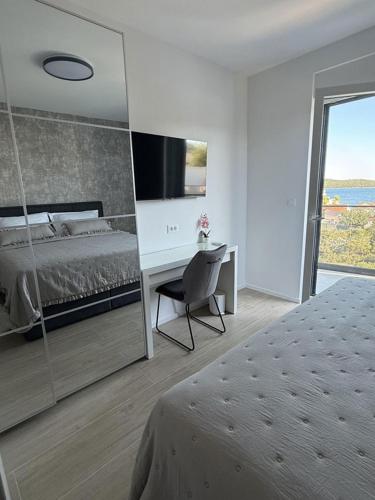 a bedroom with a bed and a desk with a television at Villa Omorfia - SEVID in Sevid