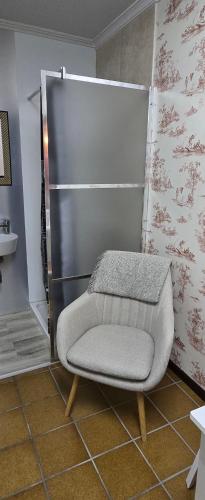 a room with a chair in front of a refrigerator at Campo do Boi A in Pontevedra