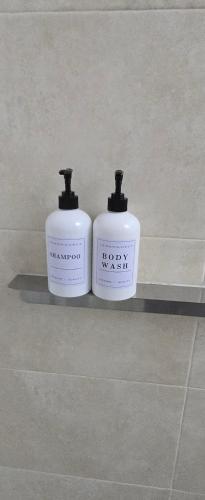 two bottles ofodorizers sitting on a shelf in a bathroom at Campo do Boi A in Pontevedra