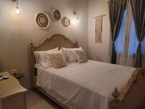 a bedroom with a bed with white sheets and pillows at City Center Suites in Karpathos