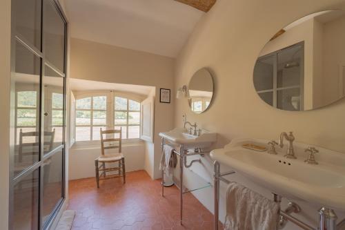 a bathroom with two sinks and a mirror at Château du Grand Pré in Vitrolles-en-Luberon