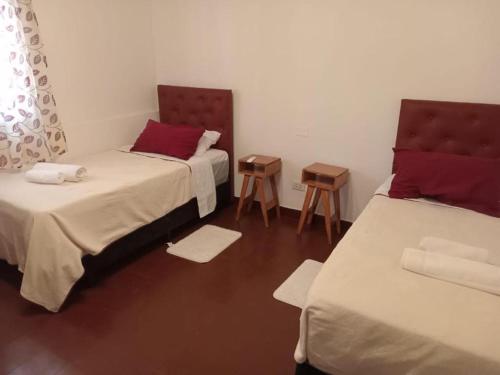 a room with two beds and two tables at Descanso de la Furia in San Carlos