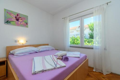 a bedroom with a purple bed with a window at Apartments Ian in Lopar