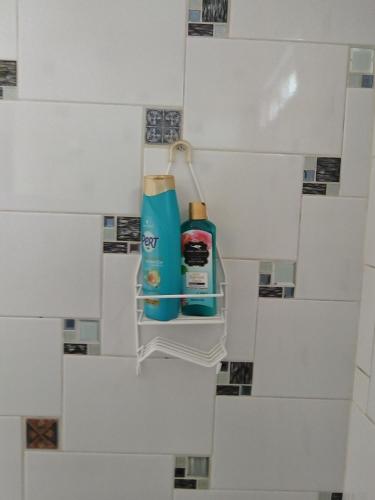 a bathroom with white tiles and a bottle of mouthwash at Roof Garden 3 in Coatepec