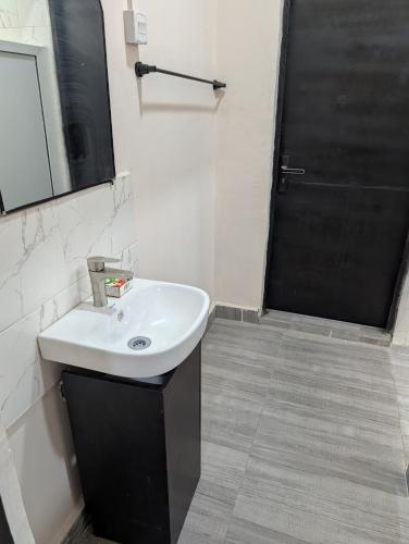 a bathroom with a sink and a mirror and a shower at Ivaeli Apartment in Lagos
