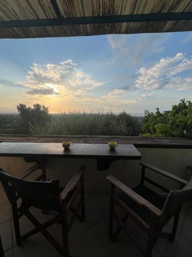 a table and two chairs on a balcony with a view at Golden Hour on the Hill in Aegina
