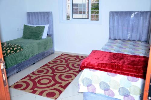 a room with two beds and a rug at إقامة جنان فاس in Fez