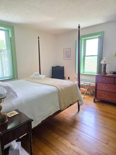 a bedroom with a large bed and a wooden floor at The Cortina Inn in Donegal