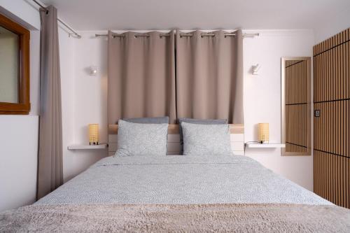 a bedroom with a large bed with two pillows at Maison les Mésanges in Flanthey
