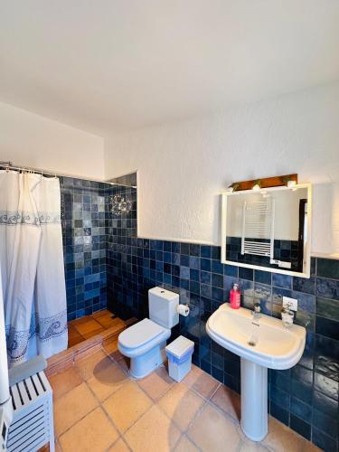 a blue tiled bathroom with a toilet and a sink at Villa Mediterraneo Rooms Piscina jardin parking in Blanes
