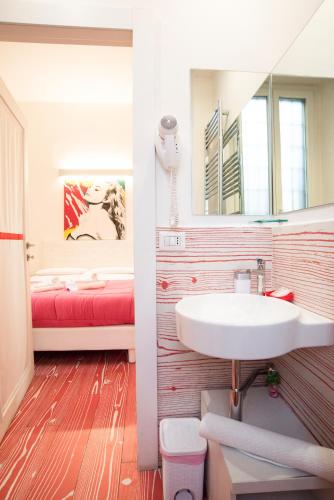 a bathroom with a sink and a mirror and a bed at Divine Bed & Breakfast in Rome