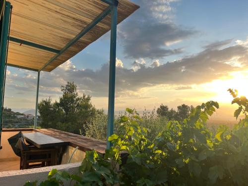 a view from a house with a table and vines at Golden Hour on the Hill in Aegina