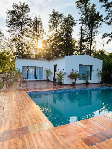 a villa with a swimming pool and a house at The cosmos farm in Gurgaon