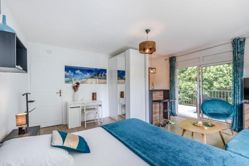 a bedroom with a king sized bed and a desk at Appartement Chic, Climatisation et Piscine in Ormoy-la-Rivière