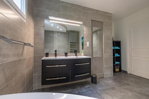 a bathroom with a sink and a mirror at Appartement Chic, Climatisation et Piscine in Ormoy-la-Rivière