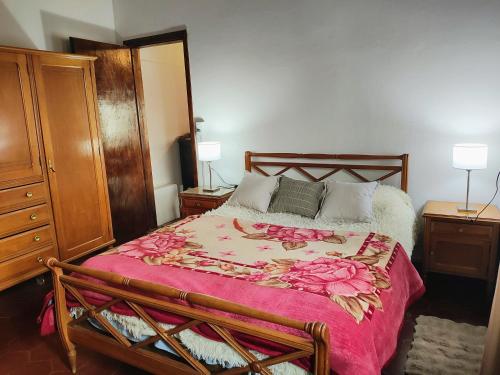 a bedroom with a large bed with a red blanket at El Quincho de Mariana in Balcarce