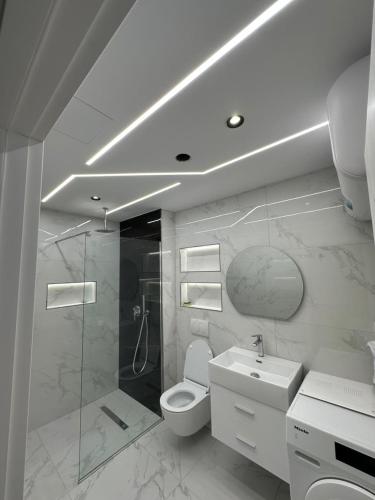 a white bathroom with a toilet and a shower at Seaview Premium Apartment in Durrës