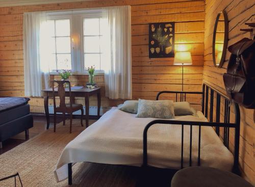 a bedroom with a bed and a table and a window at Kolin Mattila B&B in Kolinkylä
