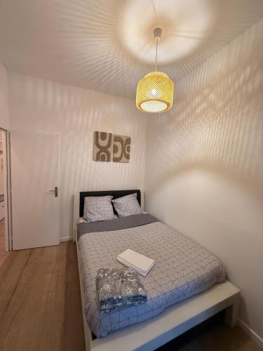 a small bedroom with a bed and a ceiling at Superbe 4 pièces luxueux in Fleury-les-Aubrais