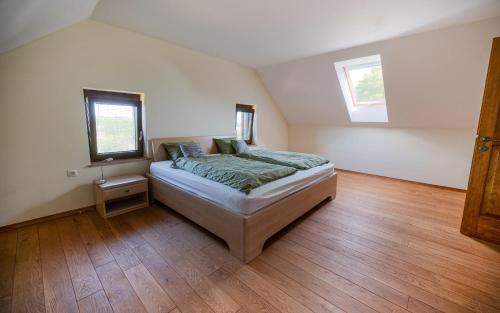 a bedroom with a bed and a wooden floor at Udobna hiša med vinogradi blizu Vinarium LEND - Comfortable Vineyard House near Vinarium Tower LEND in Lendava
