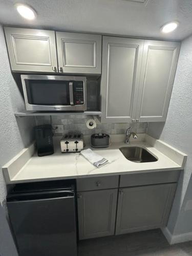 a kitchen with a sink and a microwave at Daytona Inn in Daytona Beach