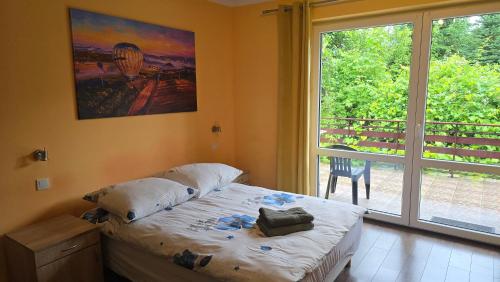 a bedroom with a bed and a large window at Stokrotka noclegi Nałęczów in Nałęczów