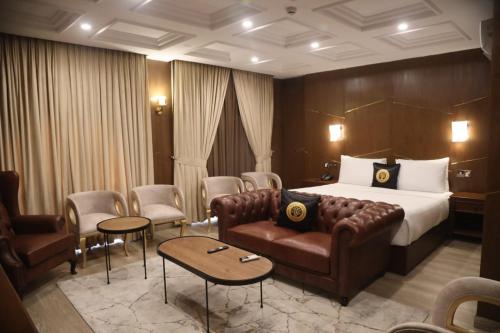a hotel room with a bed and a couch and chairs at THREE TREE Signature Hotel - G7 Markaz Islamabad in Islamabad