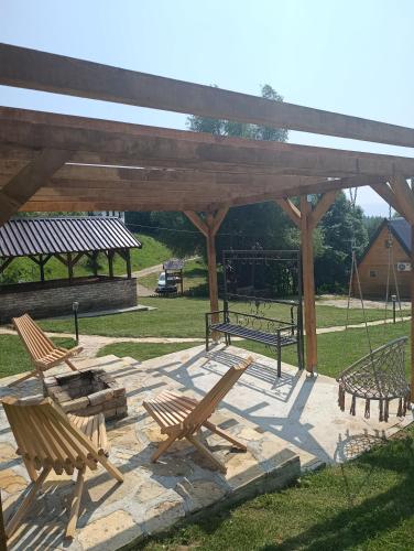 a patio with two wooden chairs and a swing at Vikendica i odmaraliste JuliE, Sarajevo-Jahorina in Tvrdimići