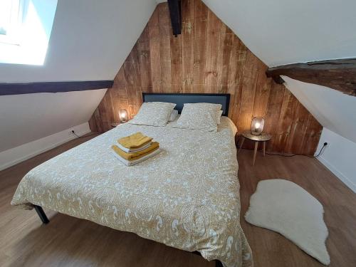 a bedroom with a bed with two towels on it at La Chaumière de Chabine in Oizon