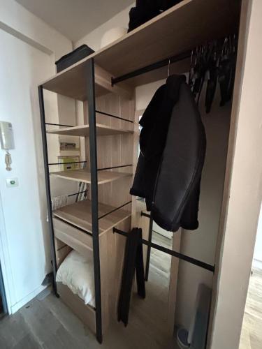 a closet with a black chair in a room at Studio plage - Séjours pros et vacances in Dunkerque