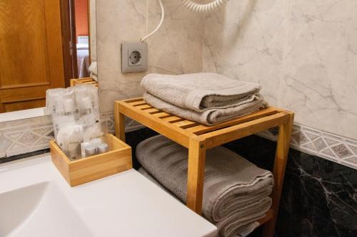 a bathroom with a table with towels and a sink at La Cassola del Priorat in Gratallops