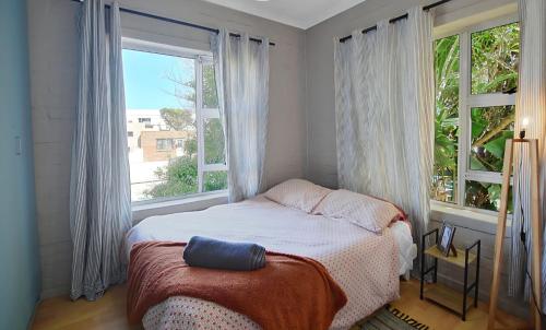 a bedroom with a bed and a large window at Skulpie in Cape Town