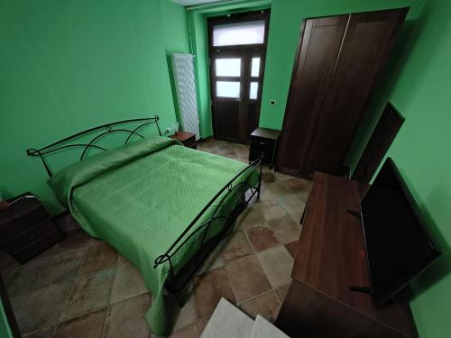 a green bedroom with a bed and a window at Avalon in Pietrelcina