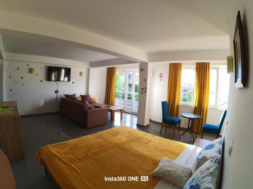 a bedroom with a bed and a living room with a couch at Yard House Trpejca in Ohrid