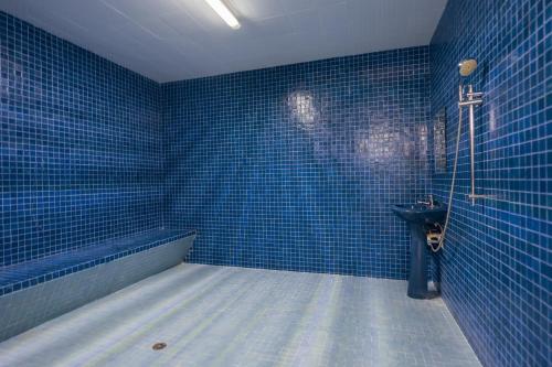 a blue tiled bathroom with a toilet and a sink at Ocean View Condo with Resort Amenities in Acapulco