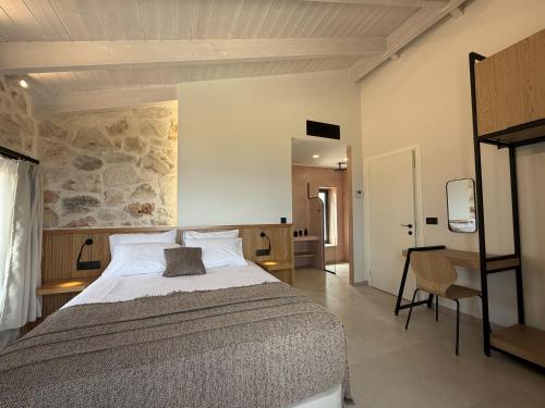 a bedroom with a large bed with a stone wall at Izel Villas in Skinária