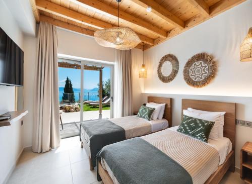 two beds in a room with a balcony at Villa Magganas in Nikiana