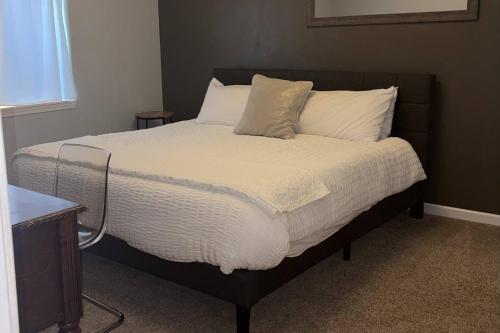 a bedroom with a bed with white sheets and pillows at Glen Eagles King Nook in Colorado Springs