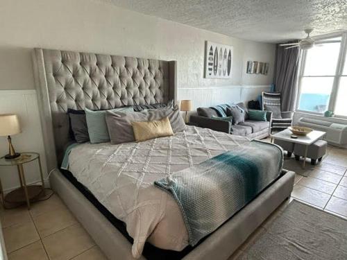 a large bedroom with a large bed and a couch at Luxury Beach Condos with Pool and Tiki Bar! in Daytona Beach