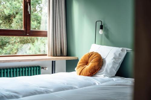 a bed with a pillow on it with a window at ReCenter in Brecht