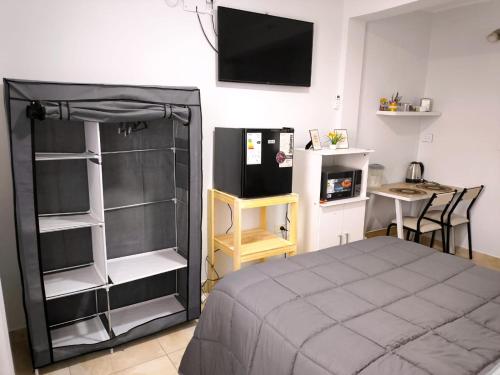 a bedroom with a bed and a tv on the wall at Departamento Letty Petit - Con Cochera in San Salvador de Jujuy