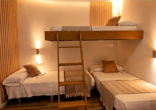 a room with two bunk beds and a ladder at Arrels Terra - Apartamento boutique mediterráneo in L'Ampolla