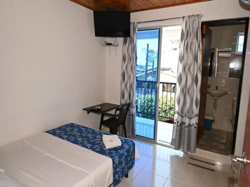 a bedroom with a bed and a view of a balcony at Hotel Bahía Cadi in Puerto López